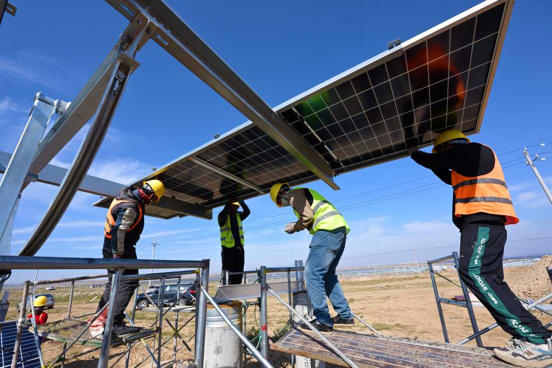 Workers install solar panels in Ningxia, northern China.